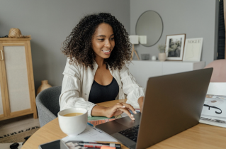 Smiling Business Woman Typing on Massive Laptop